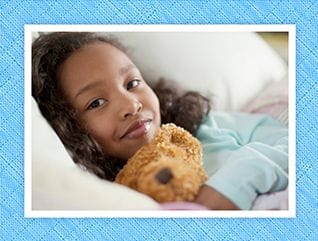 girl in pajamas holding teddy bear