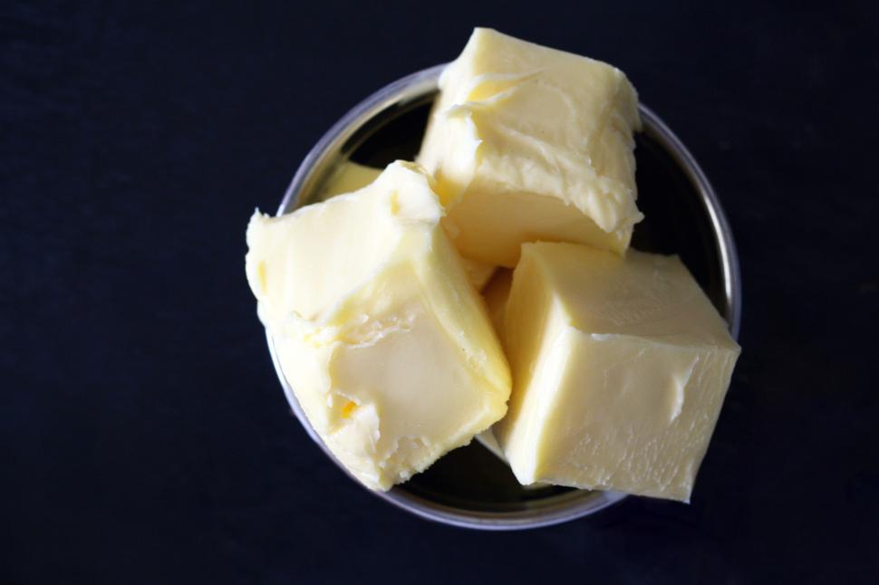 a bowl of butter on a black surface