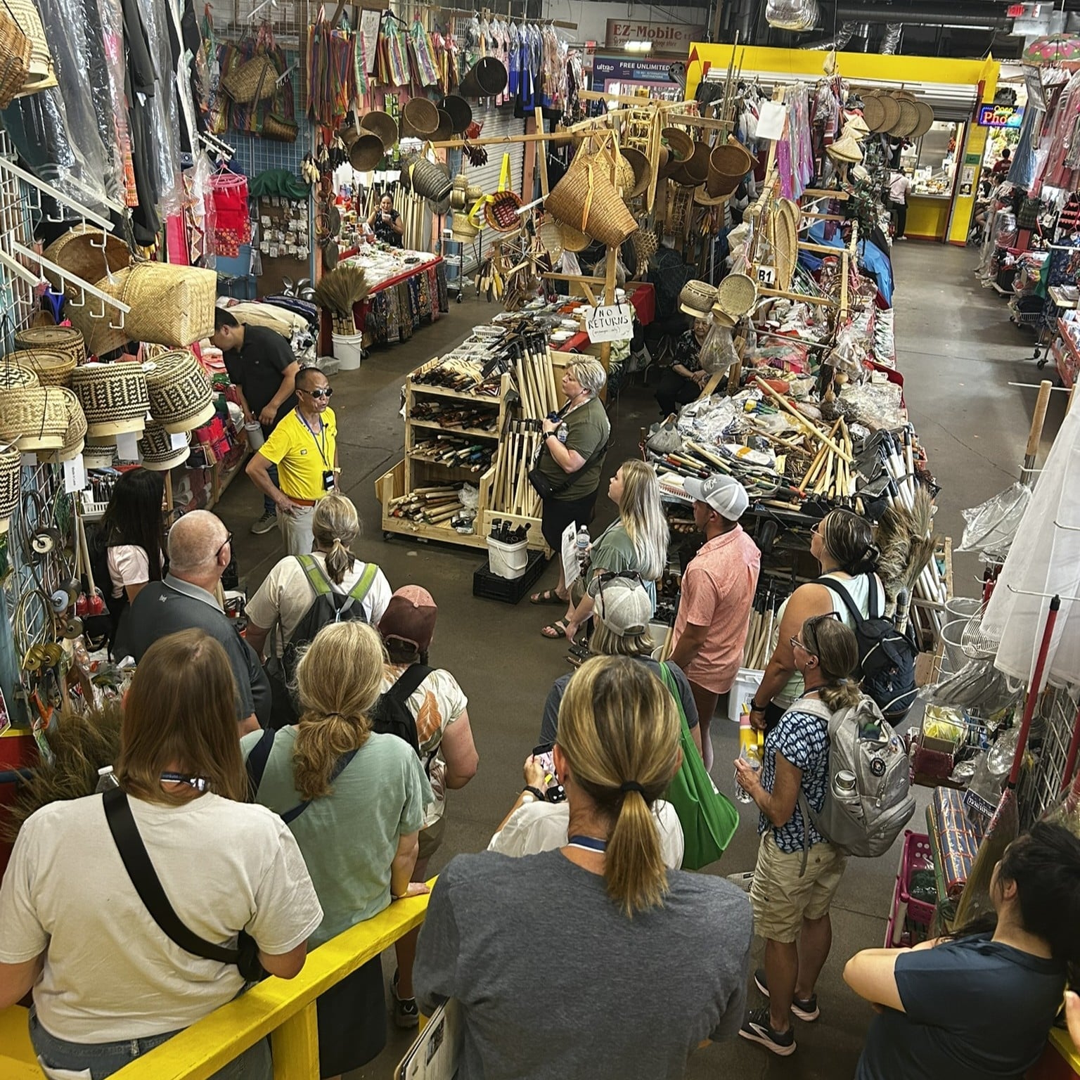 Tour guide speaking to a group in a circle while inside a marketplace