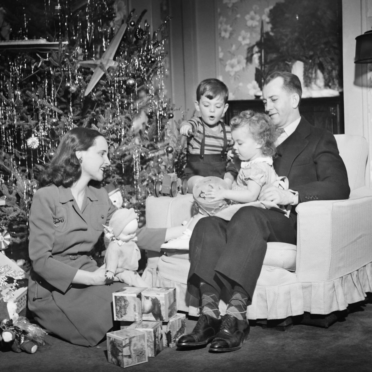 Family opening Christmas presents, children (2 3) (4 5), (B&amp;W)