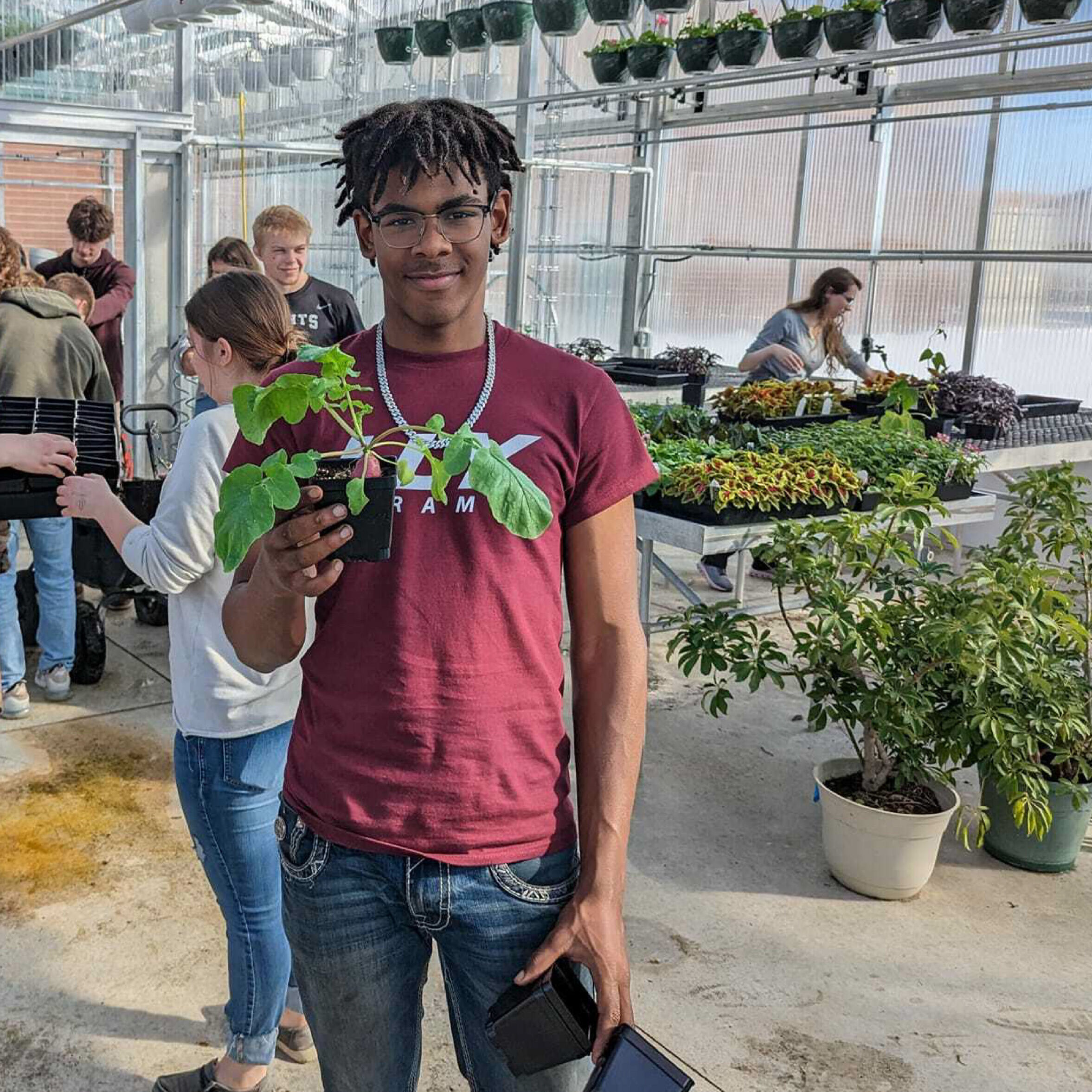 High School Student Holding Plant